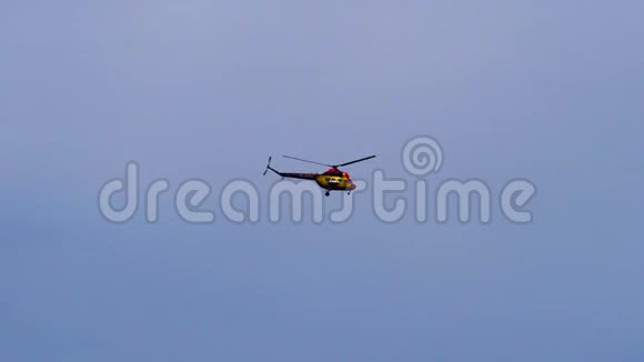 一架红黄相间的直升机在云层之间飞过天空这架直升机正忙于它的业务视频的预览图