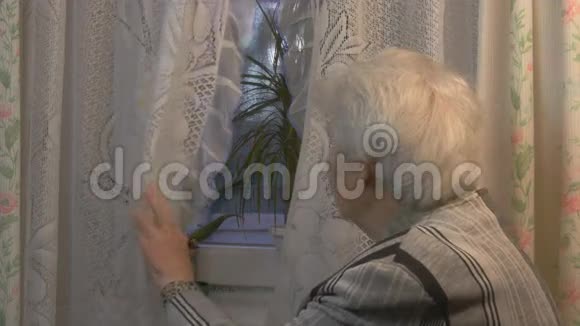 一位老年妇女望着窗户视频的预览图