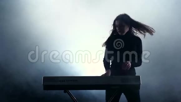 女孩在电子钢琴上演奏快速音乐抽烟工作室视频的预览图
