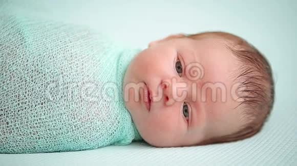 蓝眼新生婴儿躺着惊奇地环顾四周视频的预览图