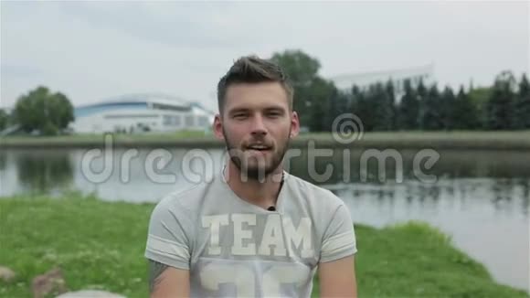 留着胡子的年轻有魅力的人在河岸上接受采访视频的预览图
