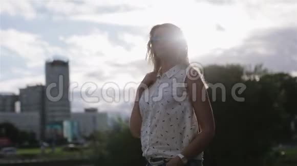 一个戴太阳镜的金发女孩欣赏风景视频的预览图