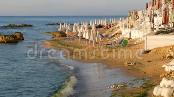 海上豪华度假度假海滩上空的多色日光浴或日光浴床和折叠的海滩伞视频的预览图