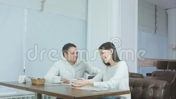 自信的侍者端着沙拉端着桌子而漂亮的夫妇看着他微笑着视频的预览图