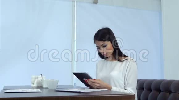 在咖啡馆里使用数码平板电脑的女商人视频的预览图