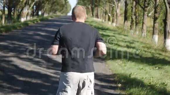 在森林小路上户外跑步的成年男子在大自然中慢跑的老人视频的预览图