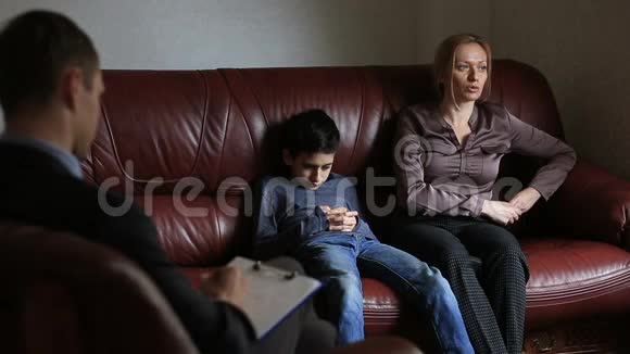 心理医生的咨询男性心理学家与一名妇女及其十几岁的儿子进行家庭咨询视频的预览图