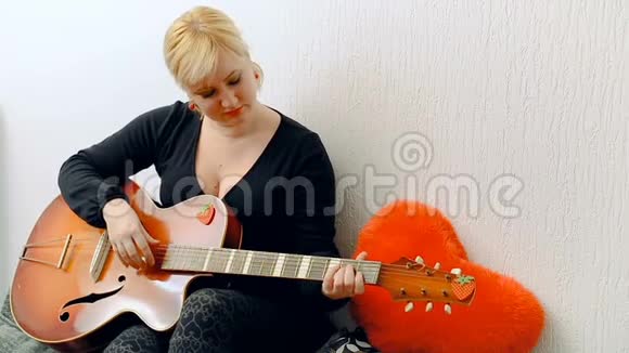 一个年轻的金发女孩唱歌弹吉他视频的预览图