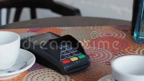 咖啡馆里的女商人正在使用智能手机和终端来支付价格视频的预览图