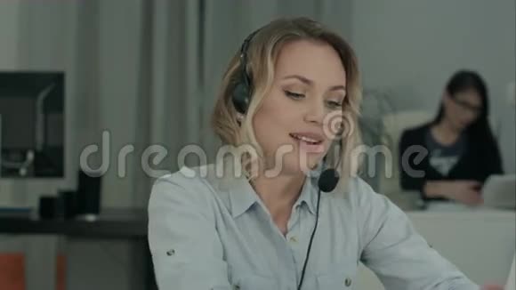 年轻女性耳机经理通过笔记本电脑进行商务讨论视频的预览图