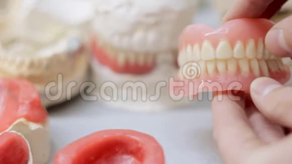 假牙在牙齿模型的背景下点击视频的预览图
