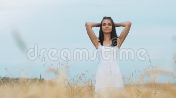 浪漫的女人走在金色的大麦地视频的预览图