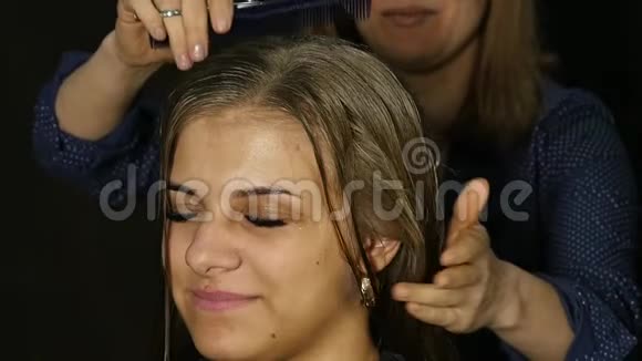 美容师为美容院的女性客户将头发与梳子分开视频的预览图