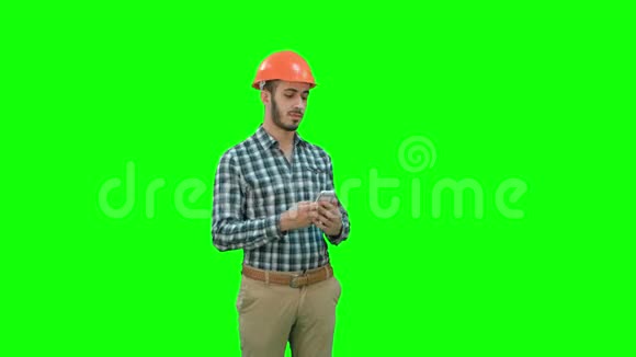 建筑工人用电话在绿色屏幕上拍摄自拍铬键视频的预览图