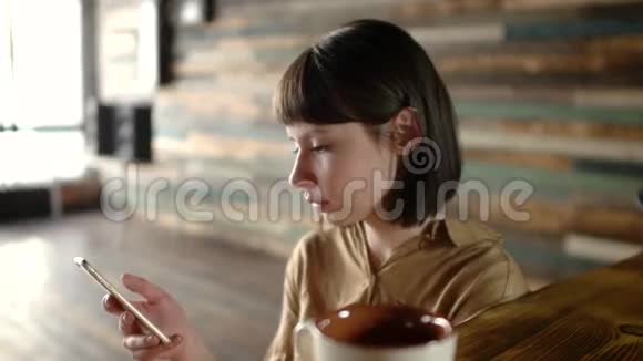 在咖啡馆里使用智能手机应用软件的美女视频的预览图