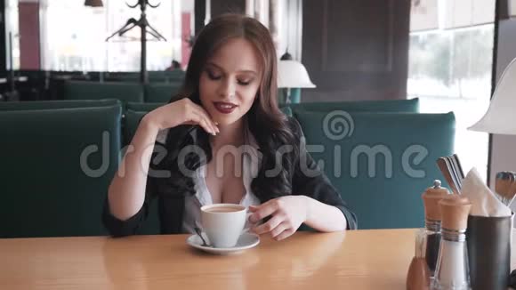 年轻时髦的女商人在咖啡馆休息她很性感微笑做梦她调情视频的预览图