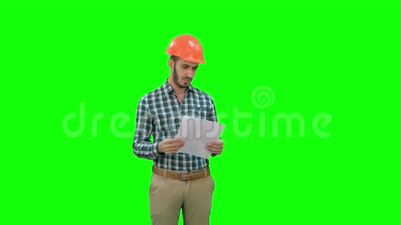 工程师在硬帽看施工计划在一个绿色屏幕铬键视频的预览图
