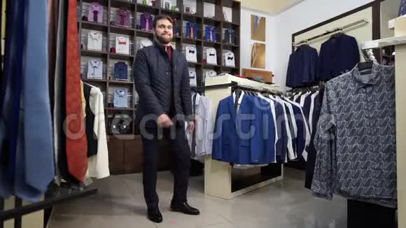 年轻有魅力的男人留着胡子穿着商务西装在一家男装店跳舞视频的预览图