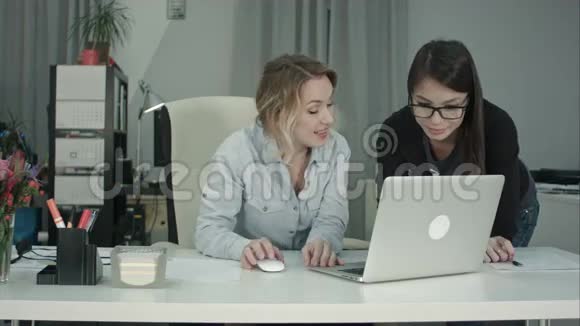 两位女同事在讨论新项目构想时使用笔记本电脑视频的预览图