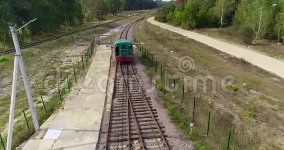 小火车头沿着森林里的铁路行驶绿色火车头沿着森林路空中行驶视频的预览图