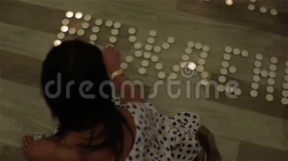 一个黑发女人在地板上点蜡烛视频的预览图