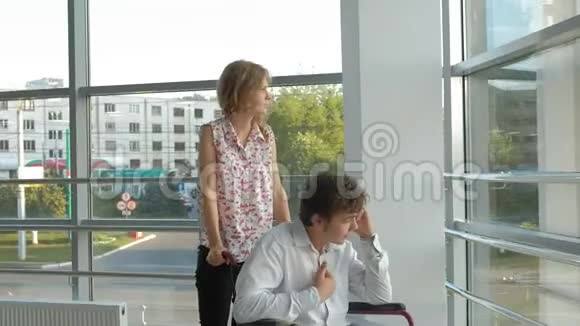 商务女性驾驶轮椅一个残疾人商人坐在轮椅上正在打电话视频的预览图