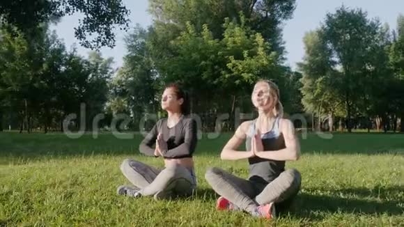 两个漂亮的女孩在户外做瑜伽视频的预览图