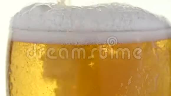 把杯子里的啤酒倒入白色的杯子里视频的预览图
