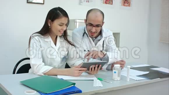两名医务人员看着平板电脑上的一些有趣的东西笑了起来视频的预览图