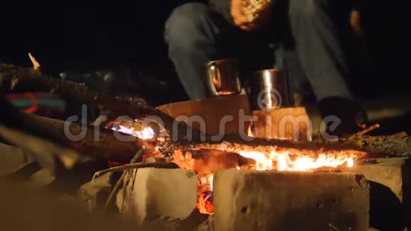 在晚上的营火里烧篝火在水壶里煮饭旅行徒步旅行冒险露营视频的预览图