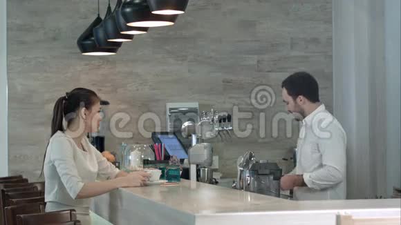 一个微笑的咖啡师和一个正在喝完饮料的女客户交谈视频的预览图