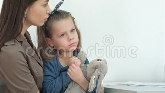 妈妈把体温计还给医生而她的女儿在和兔子玩耍视频的预览图