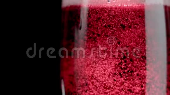 闪闪发光的红酒红酒被倒入一杯黑色的背景中慢动作视频的预览图
