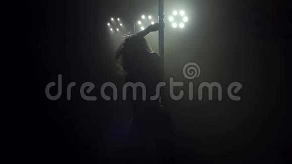 一个舞者在灯光下在黑暗中跳极子舞的肖像视频的预览图