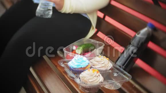亲近一个可爱的小胖女孩在蛋糕和蔬菜之间潜水坐在咖啡馆的长凳上概念是一个视频的预览图