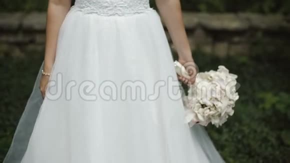 微笑的新娘穿着完美的婚纱和美丽的白色花束视频的预览图