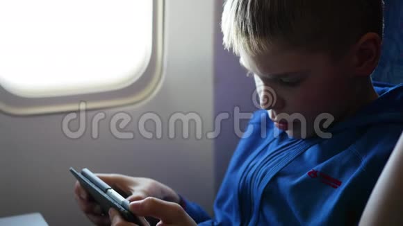 小孩把手机放在靠近窗户的飞机上视频的预览图