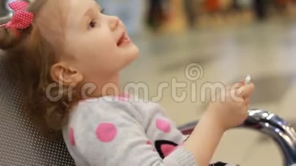 坐在候机室里玩手机的机场候机楼里的女孩视频的预览图