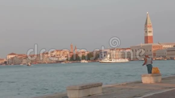 高加索人在威尼斯夏季日出的背景下捕鱼视频的预览图