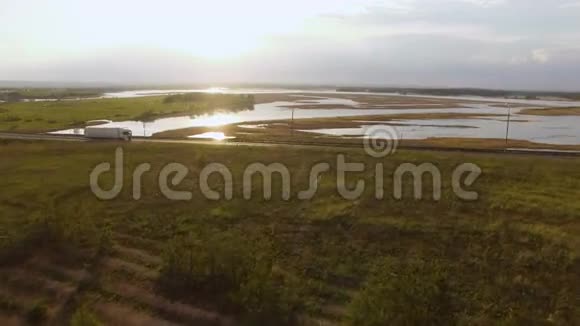 美丽的风景和骑在公路上的卡车在日落空中景色视频的预览图