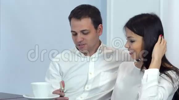 一对年轻夫妇在咖啡馆打电话视频的预览图