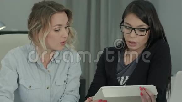 两位女同事用平板电脑在办公室里集思广益视频的预览图