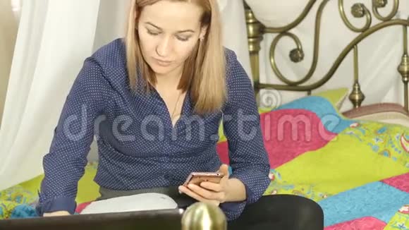 漂亮的女人在家里在线学习用她的智能手机工作簿和笔记本电脑4公里视频的预览图