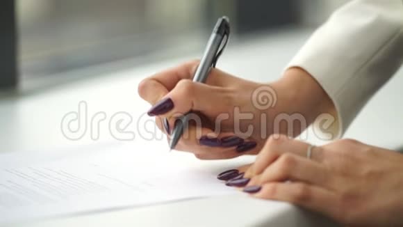 女人的特写她的手在纸上写字视频的预览图