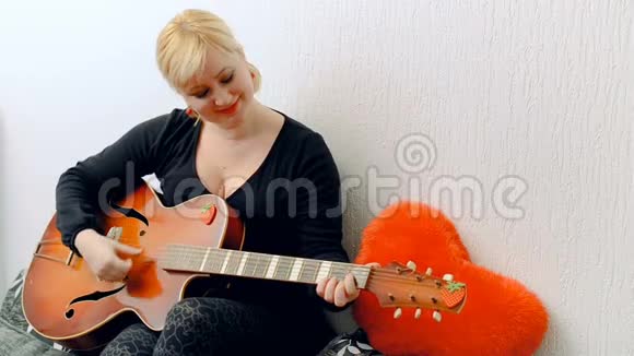 年轻的金发女孩弹吉他视频的预览图