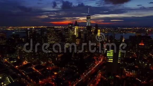 纽约市纽约市中心的摩天大楼和塔楼在明亮的夜晚灯光下鸟瞰4k视频的预览图