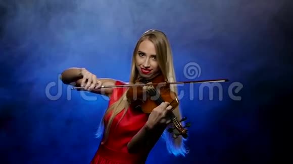 金发女郎是小提琴专业演奏家烟熏背景慢动作视频的预览图