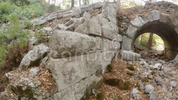 在森林中古老的奥利姆波斯城的废墟上巨大的石头毁坏了罗马剧院的拱形入口全景视频的预览图