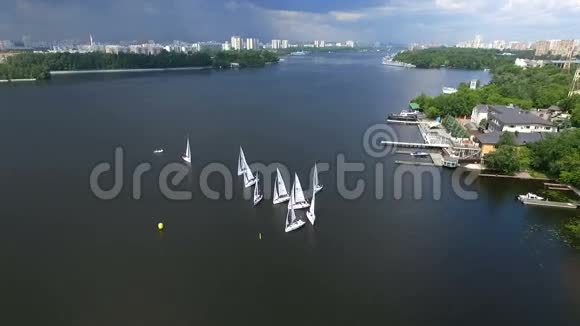 射鸟眼睛飞的无人机缓缓飞过碧水河两岸美丽的酒店游艇码头视频的预览图