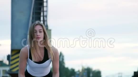 肖像年轻运动女人在厚厚的运动的绳子的帮助下进行力量练习黎明时分沿着视频的预览图